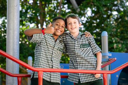 Students standing together on playground equipment, highlighting friendship, belonging and positive relationships within the primary school community