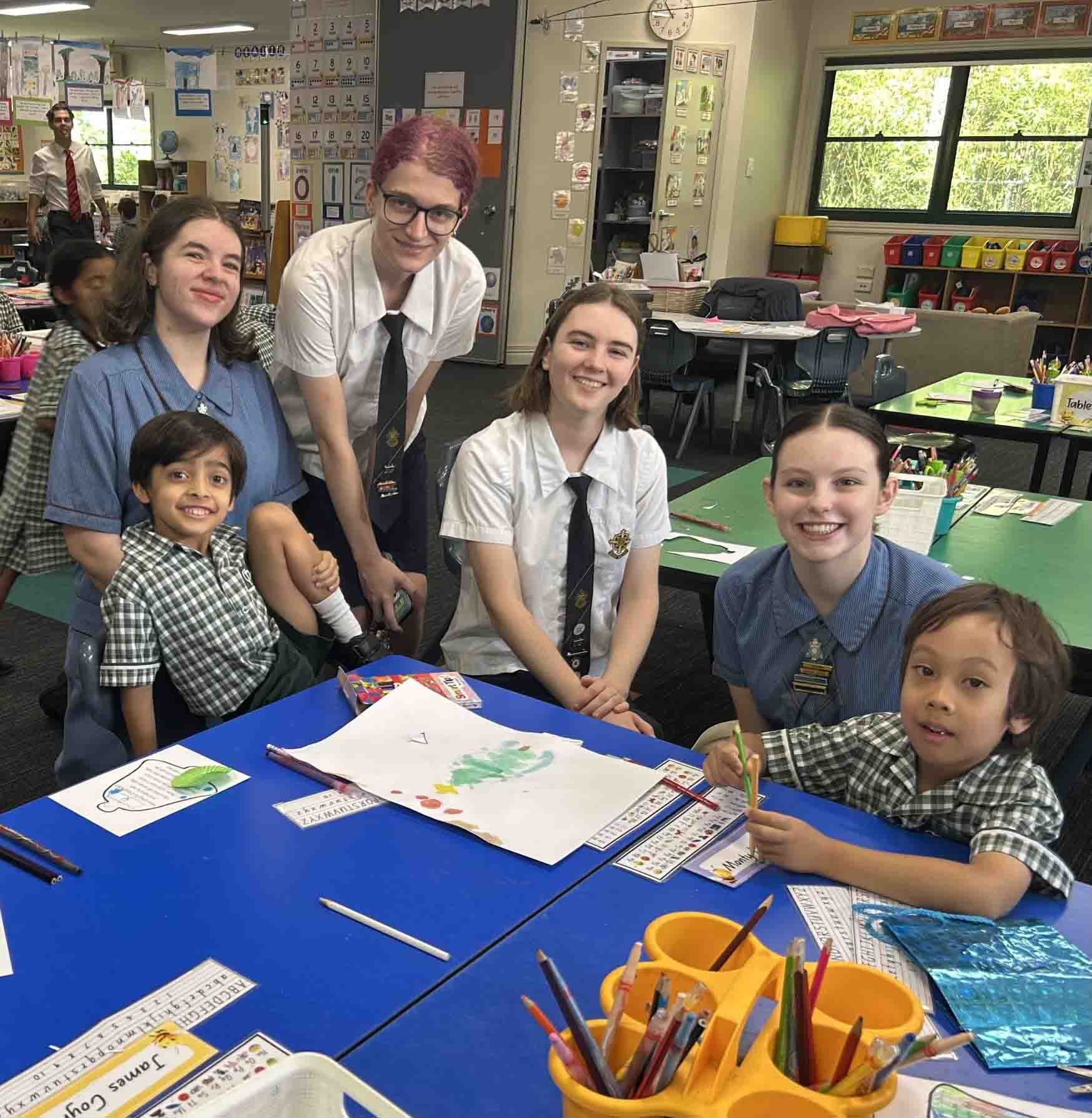 Older students working alongside younger students in a classroom activity, highlighting mentoring, collaboration and shared learning across year levels